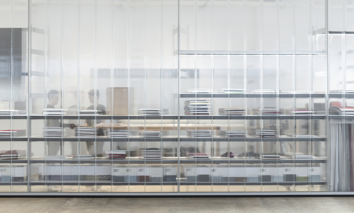 The transparent glass screens effectively separate the offices from the warehouse spaces and presentation areas for products.