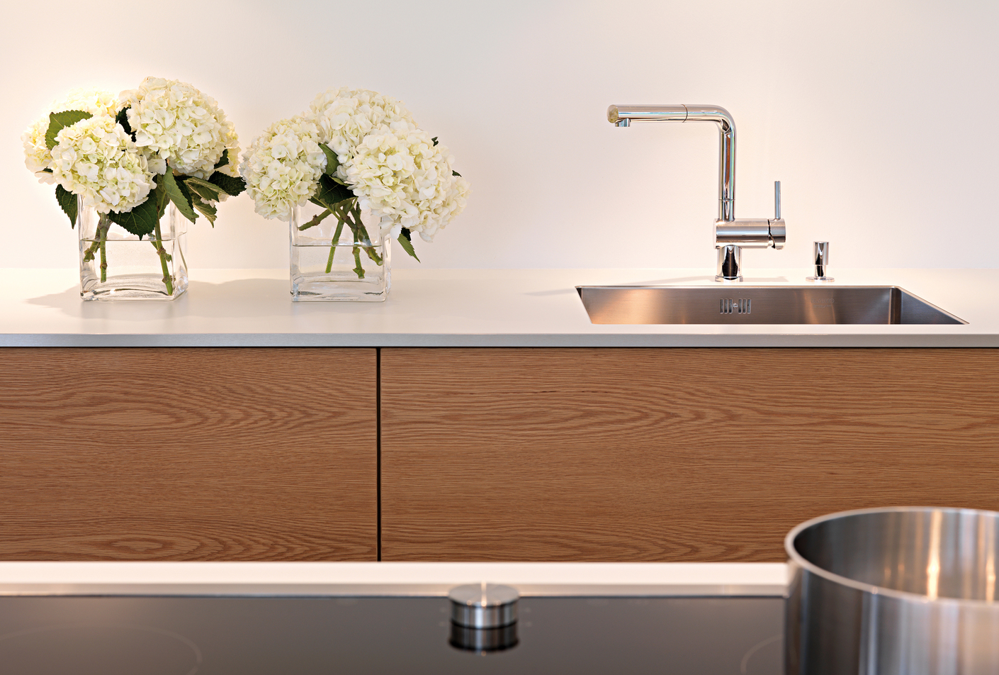 Um die kühle Wirkung der lackierten Oberflächen optisch etwas auszugleichen, fiel für die Schubladen des Einbaus die Entscheidung auf horizontal furnierte Eichenfronten.