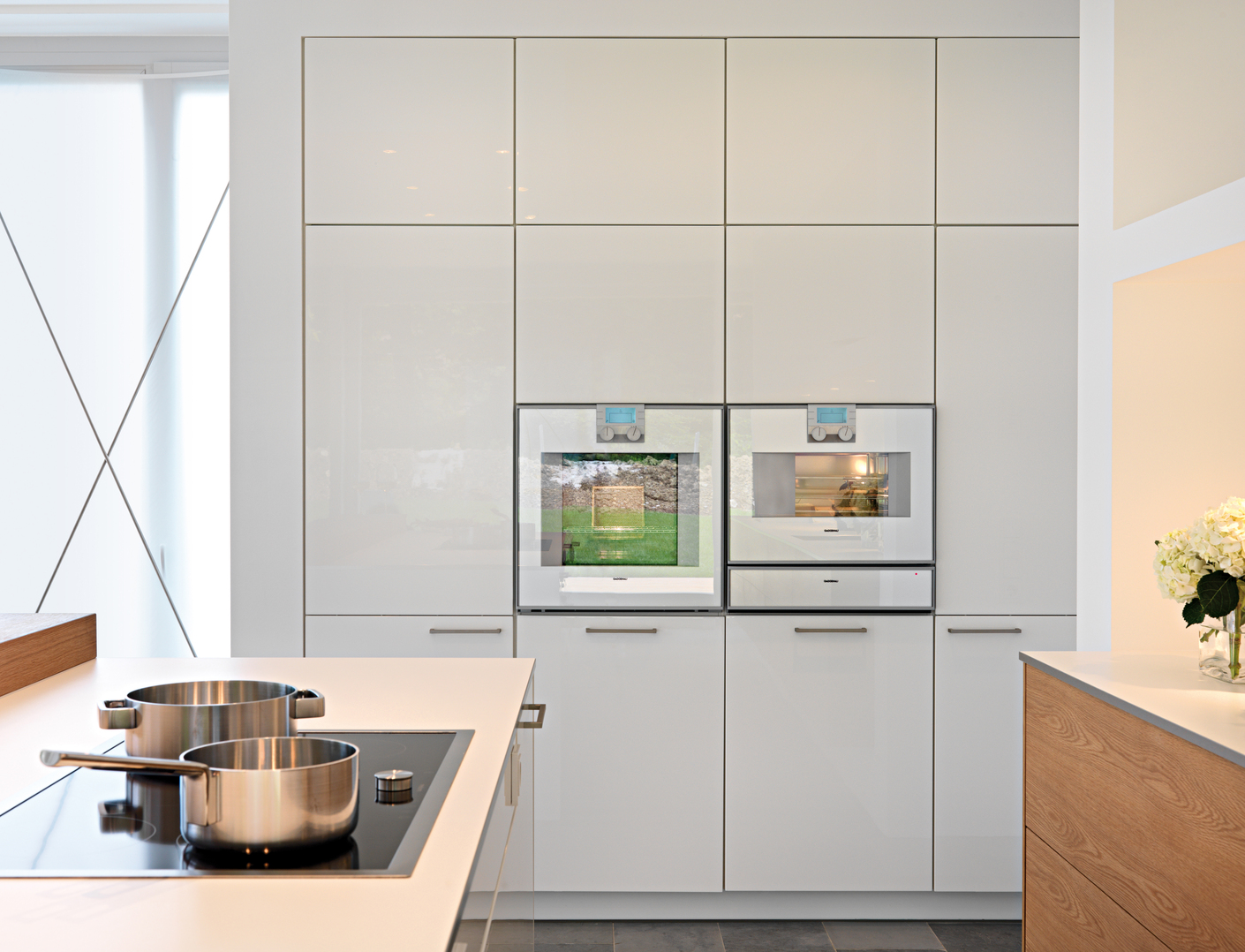 Alle Elektrogeräte hat man flächenbündig in die Hochschränke sowie in die Kücheninsel eingemauert und somit eine ergonomische Arbeitshöhe geschaffen.