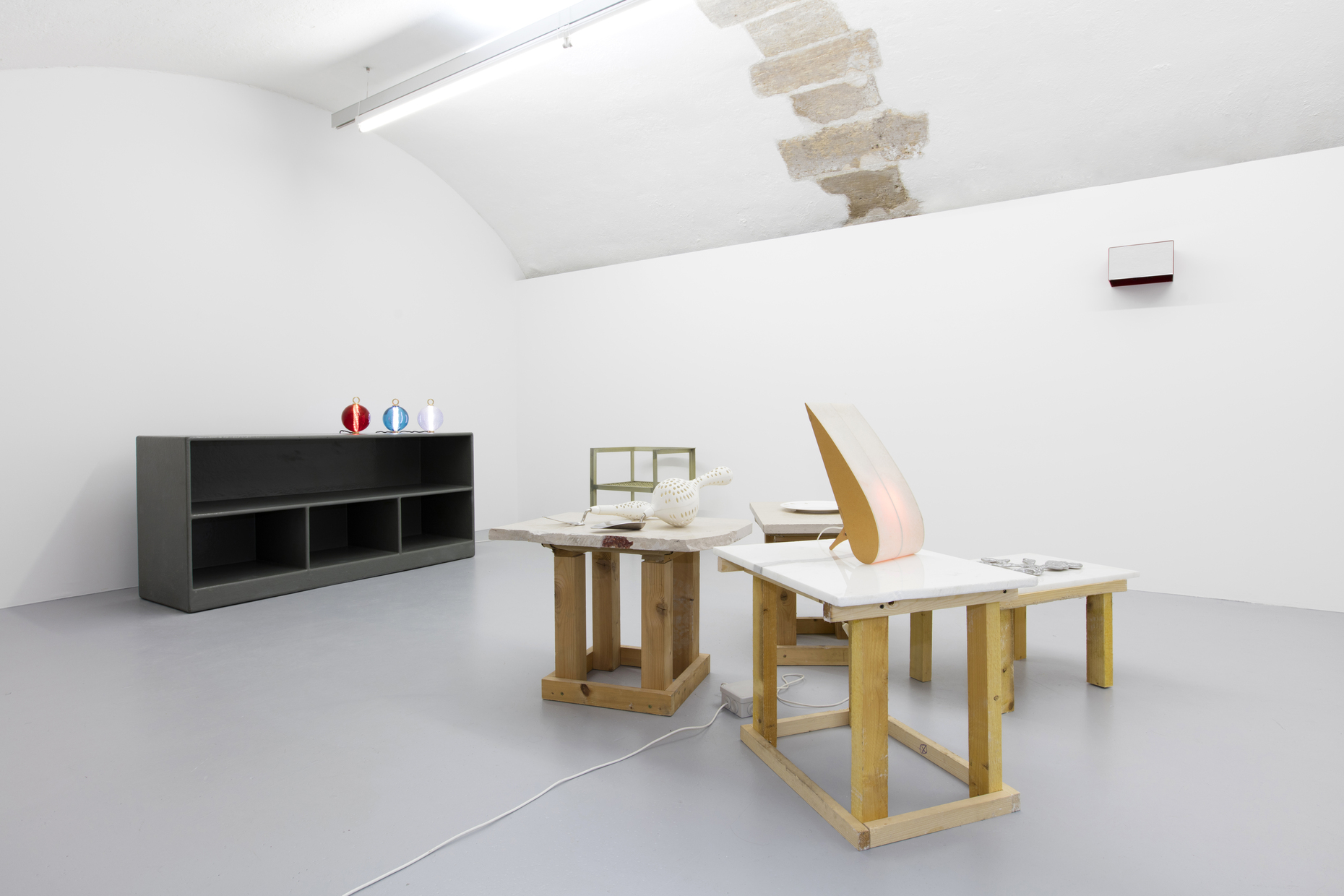 Auf den Tischen die "Tear Drop Lamp" von Anish Kapoor, "Towel and Fork" von Tony Cragg, Untersetzer von Richard Deacon, Teller von Richard Wentworth. Im Hintergrund: Bücherregal von Atelier van Lieshout und Glasleuchten von Jean-Michel Othoniel