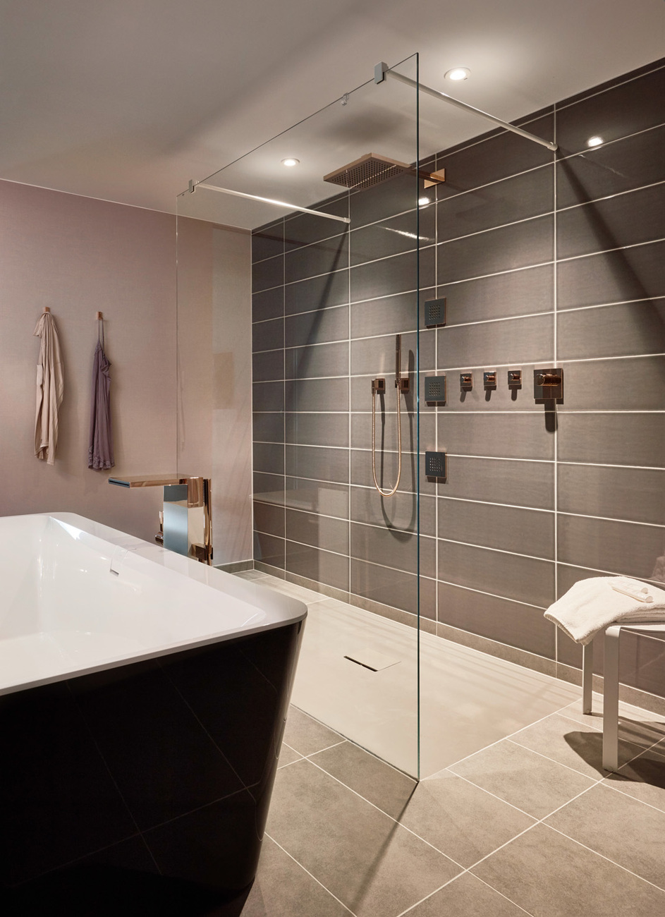 Soft-nude surfaces create a pleasant atmosphere in the bathroom in combination with matt gray tones and rich black.