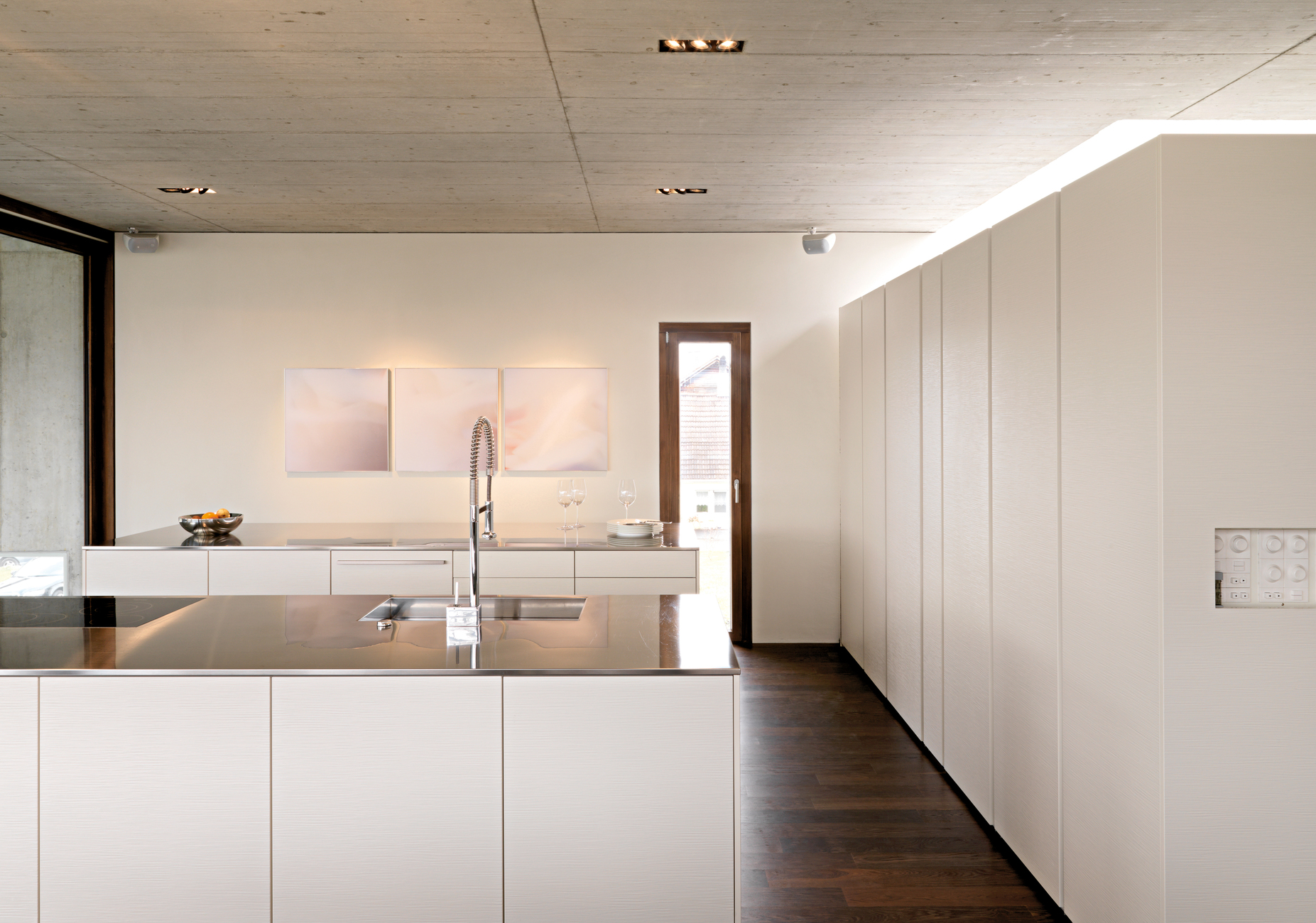 Für den Mittelpunkt des Hauses hat man parallel zum langen Esstisch zwei gleichgroße Küchenblöcke von Leicht Küchen platziert.