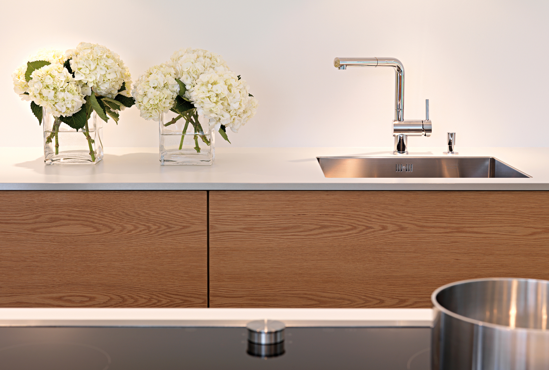 Um die kühle Wirkung der lackierten Oberflächen optisch etwas auszugleichen, fiel für die Schubladen des Einbaus die Entscheidung auf horizontal furnierte Eichenfronten.