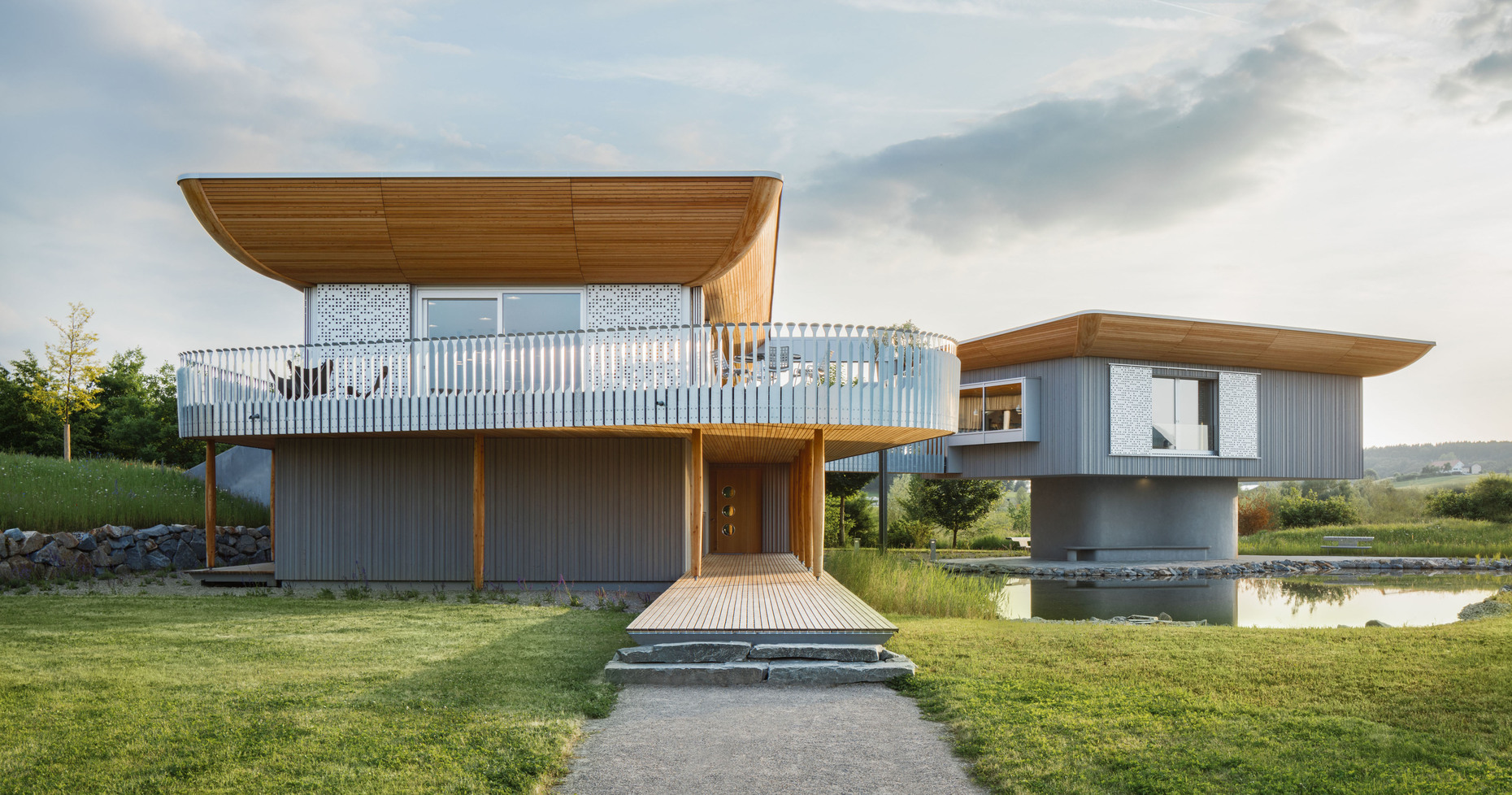 Das Systemhaus aus Holz erinnert mit seinen bugartigen Dachformen an ein Schiff und steht für eine neue Wohnästhetik, die Ökologie und Design miteinander verbindet.