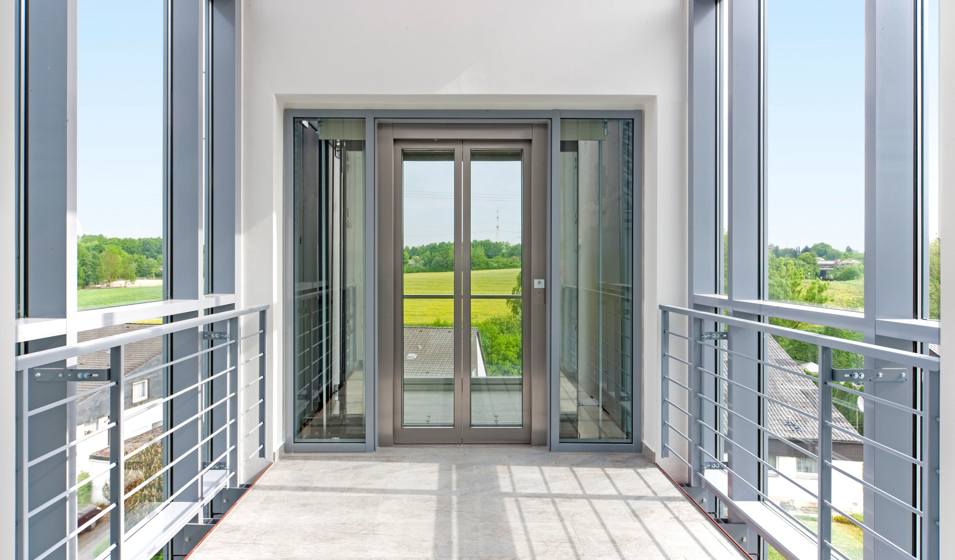 A small air bridge in the new structure leads to the glazed elevator. Thanks to the transparent front tenants enjoy a panoramic view from the upper floors.