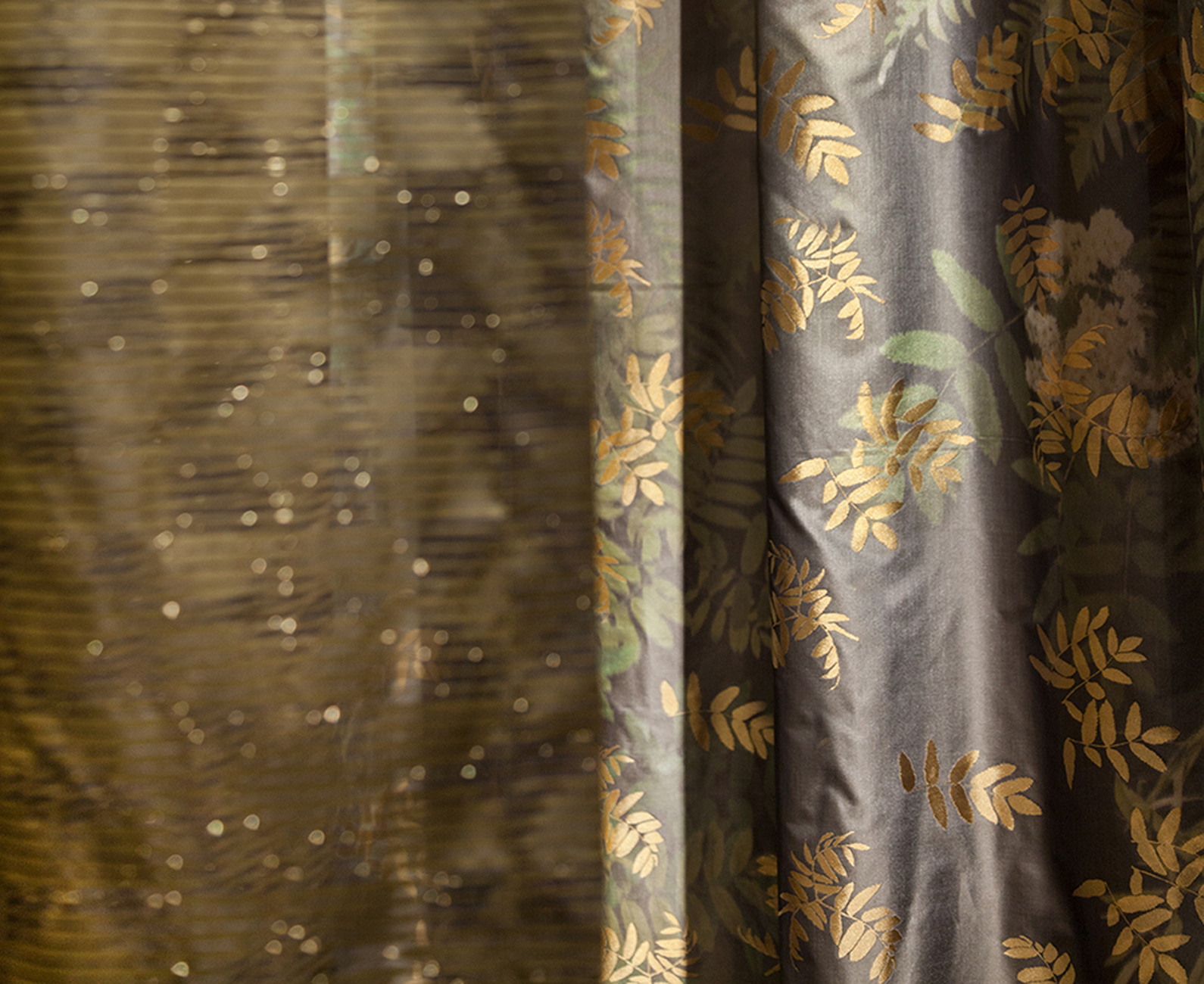 Goldene Zweige: Der Stoff „Ashley“ von Nya Nordiska mit glänzenden Blütenmotiven.