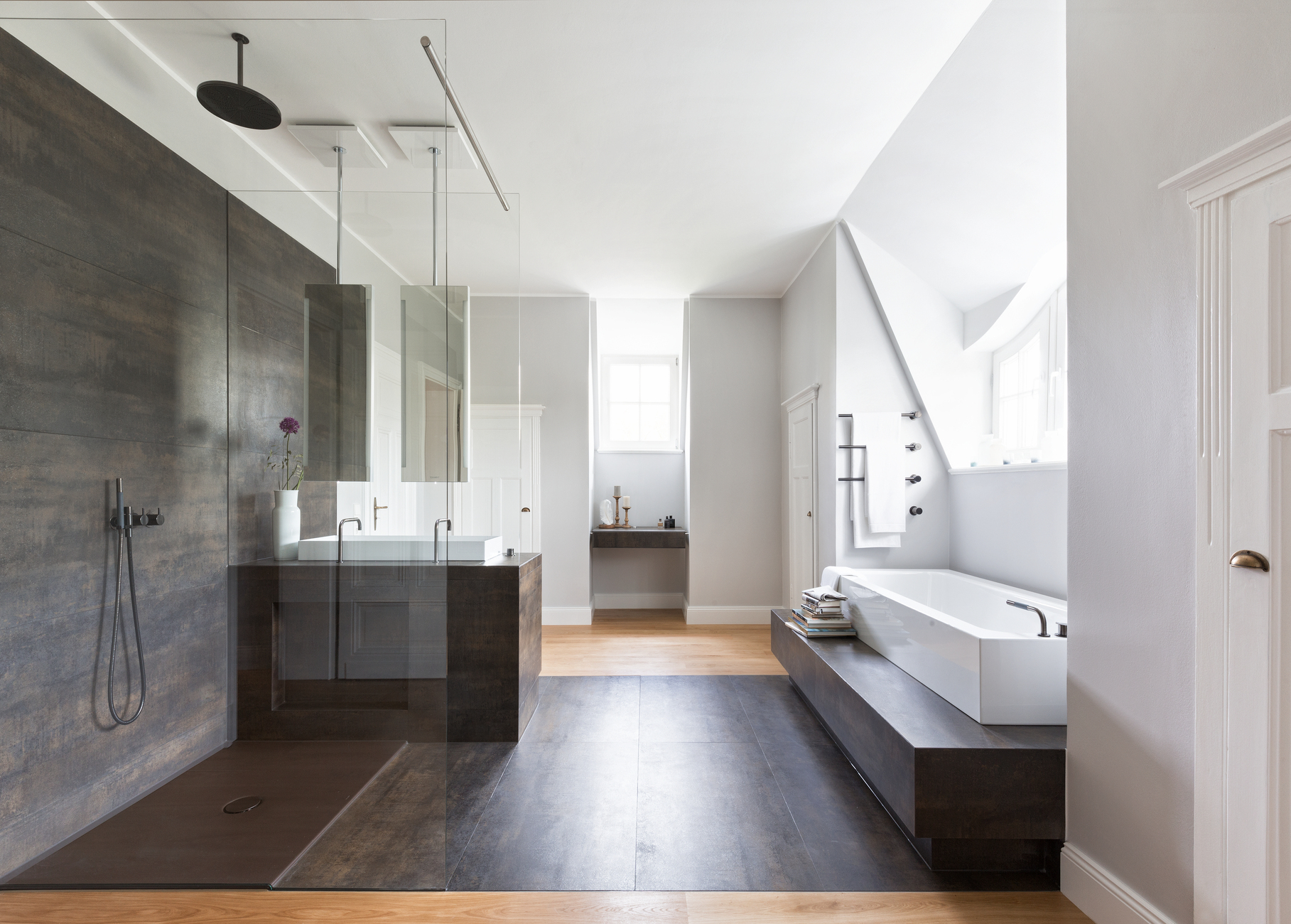 The materials and colors clearly distinguish the old from the new: bright gray fine plaster, oak floorboards and wood lacquered white contrast with dark moiré fine stoneware and glass.