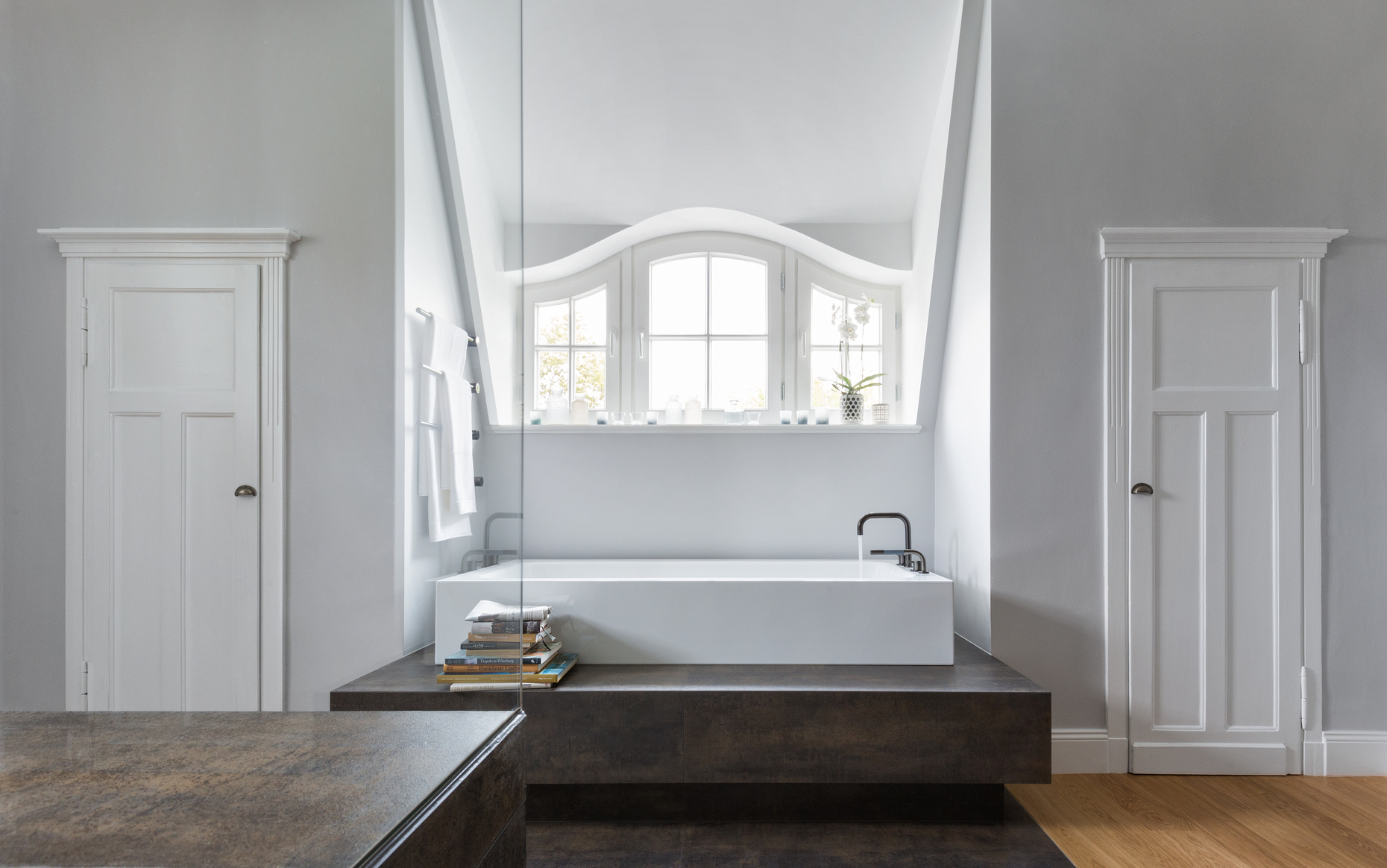 The bathroom is now a bright room which, with its beautiful dormer windows and doors still brings the original building to mind, but is otherwise awash in modern life.