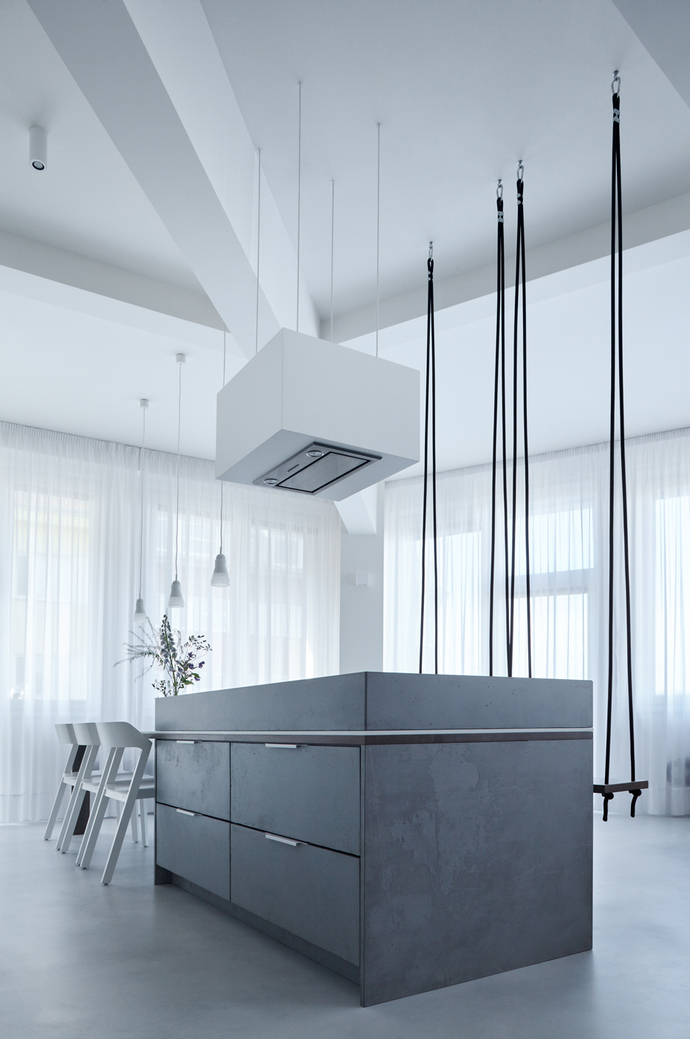 Klára Valová from Studio SMLXL decided to use a kitchen island made of gray stained wood for the open-plan living room.