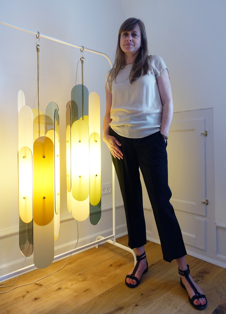 Danish designer ​Vibeke Fonnesberg Schmidt​ standing next to her "Stafa"-Lamp (plexiglas in various degrees of translucence and brass​).